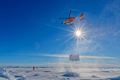 Die Helikoper sind eine wichtige Unterstützung bei der Expedition: Sie helfen bei der Erkundung des Eises oder wie hier bei Transport von Material auf die Scholle. Foto: Lianna Nixon, University of Colorado