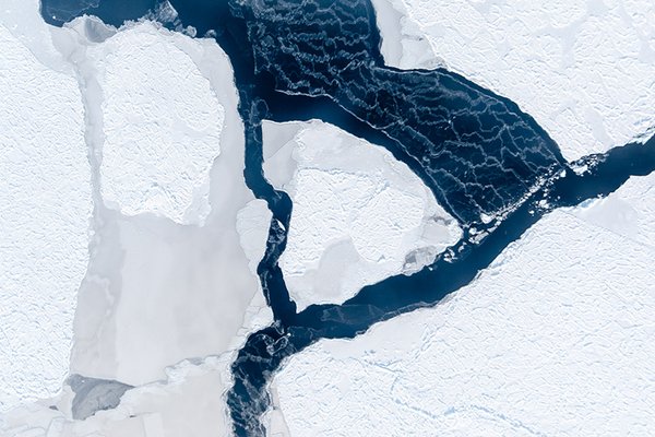 Der Wind hat ein Eisfeld auseinander getrieben und eine Fläche offenen Wassers geschaffen. Dessen Oberfläche gefriert sofort wieder, wie die weißen Schlieren verraten. (Foto: IceCam/Stefan Hendricks, Alfred-Wegener-Institut)