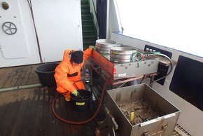 Der an Deck kommende Schlamm wird vorsichtig aufgerührt, sodass das sehr feine Sediment durch eine Siebreihe durchgespült werden kann. Foto: AWI