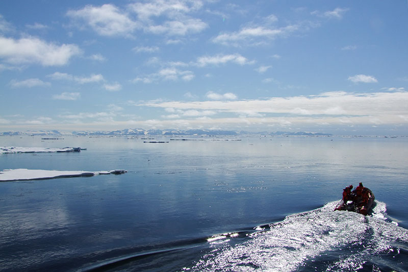 Polarstern-Expedition PS106 2017 im Arktischen Ozean nördlich von Spitzbergen: Um Einflüsse des Eisbrechers auszuschließen fahren die Forschenden für die Probennahme in Überlebensanzügen mit einem Schlauchboot auf den offenen Ozean. Weshalb sich die Arktis deutlich stärker erwärmt als der Rest der Erde, untersucht seit 2016 der Transregio 172 „Arktische Klimaveränderungen“ der Deutschen Forschungsgemeinschaft (DFG). Foto: Sebastian Zeppenfeld, TROPOS